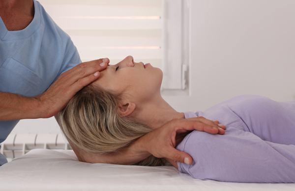 a chiropractor is performing a treatment on a lady patient's head